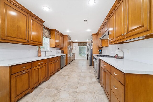 13302 Holston Hills Dr, Houston, TX 77069 - kitchen featuring appliances with stainless steel finishes, brown cabinets, recessed lighting, and ornamental molding