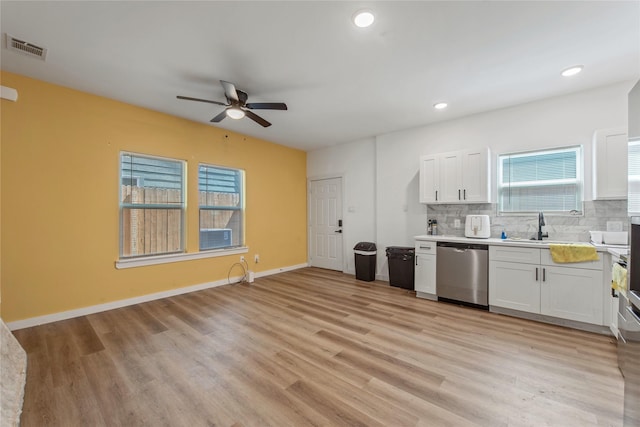 8211 Barlow St, Houston, TX 77028 - kitchen with ceiling fan, white cabinets, backsplash, stainless steel dishwasher, and light countertops