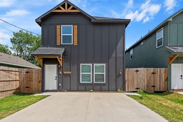 8211 Barlow St, Houston, TX 77028 - view of front of home featuring board and batten siding, a gate, concrete driveway, and a patio area