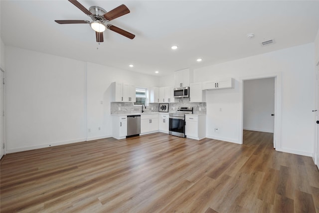 8211 Barlow St, Houston, TX 77028 - unfurnished living room featuring light wood-type flooring, ceiling fan, and recessed lighting