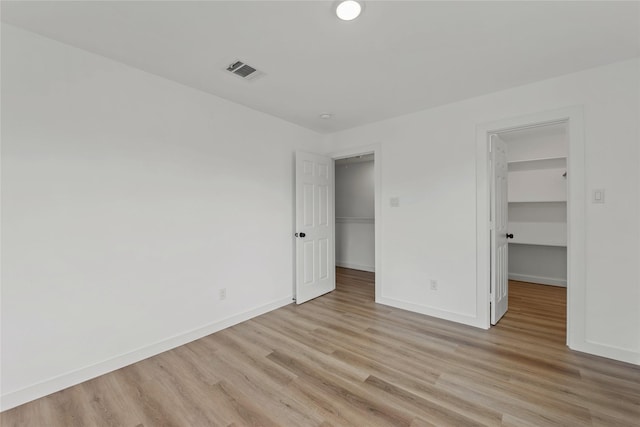 8211 Barlow St, Houston, TX 77028 - unfurnished bedroom with a walk in closet and light wood finished floors