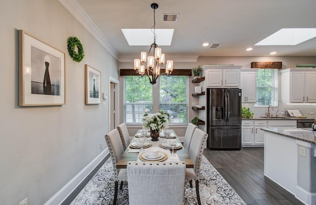 931 Shirkmere Rd, Houston, TX 77008 - dining area featuring a skylight, crown molding, a chandelier, dark wood-type flooring, and recessed lighting