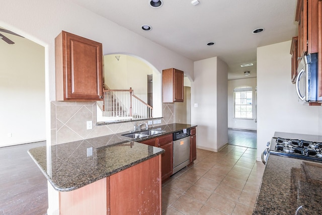 6533 Gray Birch Ln, Dickinson, TX 77539 - kitchen featuring stainless steel appliances, arched walkways, backsplash, a peninsula, and recessed lighting