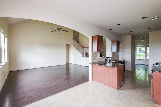6533 Gray Birch Ln, Dickinson, TX 77539 - kitchen featuring a ceiling fan, a peninsula, arched walkways, open floor plan, and backsplash