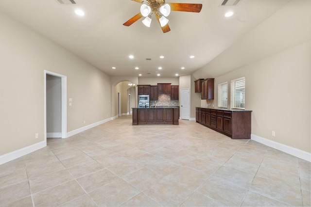 1215 Oxbow Crossing Ln, Rosenberg, TX 77471 - kitchen with arched walkways, decorative backsplash, dark countertops, open floor plan, and a ceiling fan