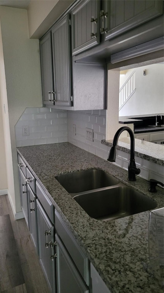 8367 Nairn St, Houston, TX 77074 - kitchen featuring gray cabinets, decorative backsplash, and wood finished floors