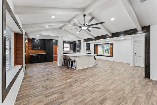 13855 Lantern Ln, Houston, TX 77015 - kitchen featuring open floor plan, dark cabinetry, a breakfast bar, light countertops, and light wood-style flooring
