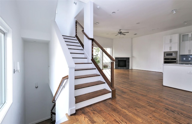 5711 Kansas, Houston, TX 77007 - stairs featuring a ceiling fan, wood finished floors, and a tile fireplace