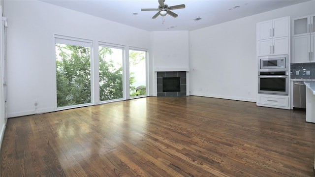 5711 Kansas, Houston, TX 77007 - unfurnished living room with a ceiling fan, dark wood-type flooring, and a tile fireplace