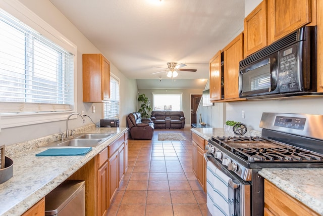 6335 Danshire Ct, Houston, TX 77049 - kitchen featuring stainless steel gas stove, black microwave, a ceiling fan, light tile patterned flooring, and open floor plan