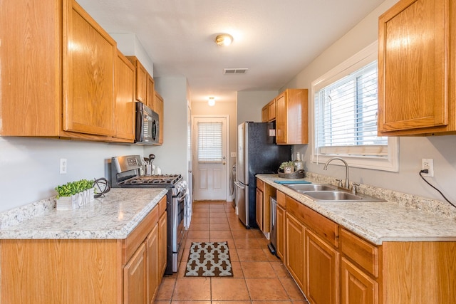 6335 Danshire Ct, Houston, TX 77049 - kitchen featuring appliances with stainless steel finishes, light countertops, healthy amount of natural light, and light tile patterned floors