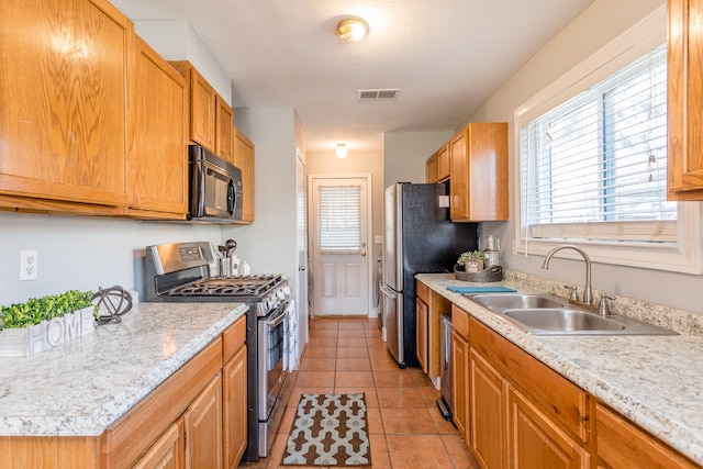 6335 Danshire Ct, Houston, TX 77049 - kitchen with stainless steel appliances, light countertops, healthy amount of natural light, and light tile patterned floors