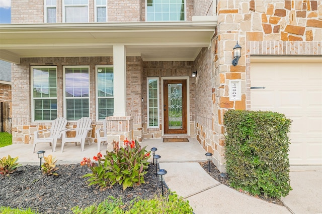 24802 Colonial Maple Dr, Katy, TX 77493 - view of exterior entry with a porch, a garage, and brick siding
