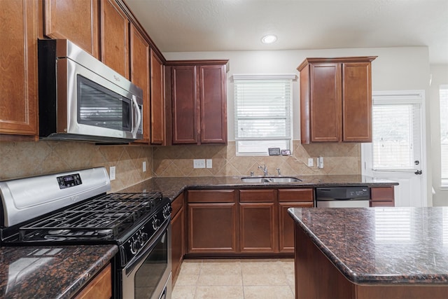 24802 Colonial Maple Dr, Katy, TX 77493 - kitchen with stainless steel appliances, backsplash, dark stone countertops, light tile patterned floors, and recessed lighting