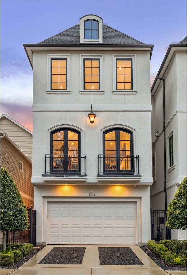 1712 Michigan St, Houston, TX 77006 - view of front of property featuring stucco siding, a balcony, a garage, and driveway