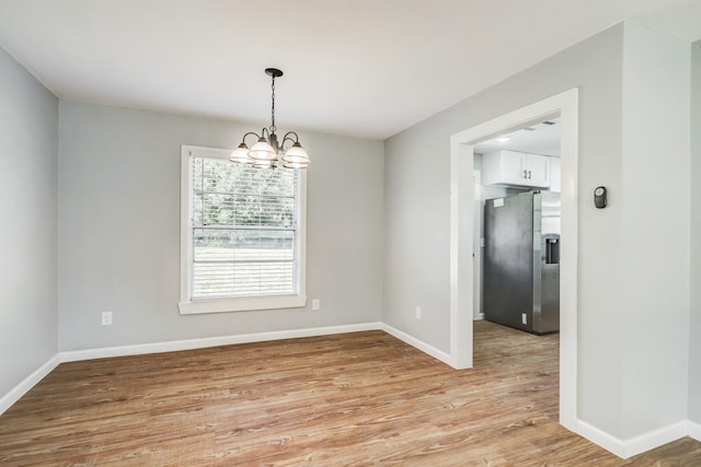 2003 Amelia St, Baytown, TX 77520 - spare room with light wood-style floors and a chandelier