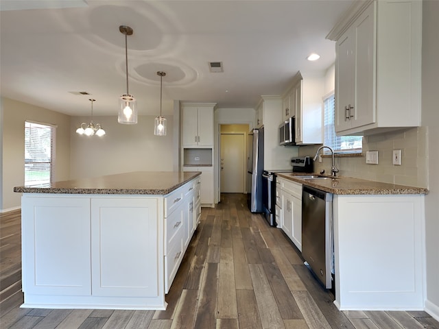 1402 Cherry Springs Ct, Missouri City, TX 77459 - kitchen featuring appliances with stainless steel finishes, a center island, dark wood-style floors, white cabinets, and recessed lighting