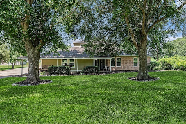 7403 Falcon Dr, Brookshire, TX 77423 - view of front of home featuring a front lawn, a carport, driveway, and covered porch