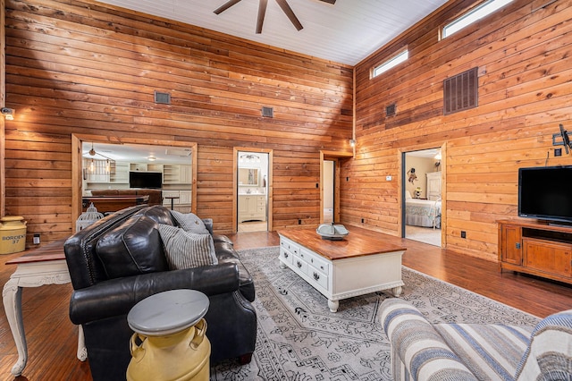 7403 Falcon Dr, Brookshire, TX 77423 - living room with a ceiling fan, wood walls, wood finished floors, and a towering ceiling