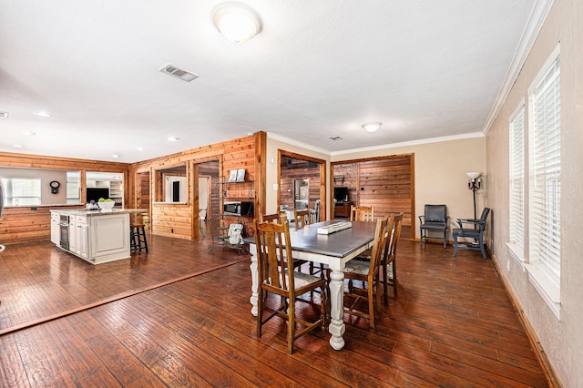 7403 Falcon Dr, Brookshire, TX 77423 - dining room with dark wood-style floors, ornamental molding, and wooden walls