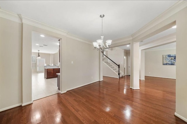 8123 Spring Bluebonnet Dr, Sugar Land, TX 77479 - unfurnished dining area featuring a chandelier, wood finished floors, ornamental molding, and stairs