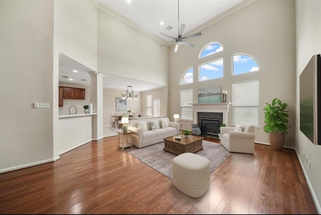 8123 Spring Bluebonnet Dr, Sugar Land, TX 77479 - living room with ornamental molding, wood finished floors, a premium fireplace, a ceiling fan, and a chandelier