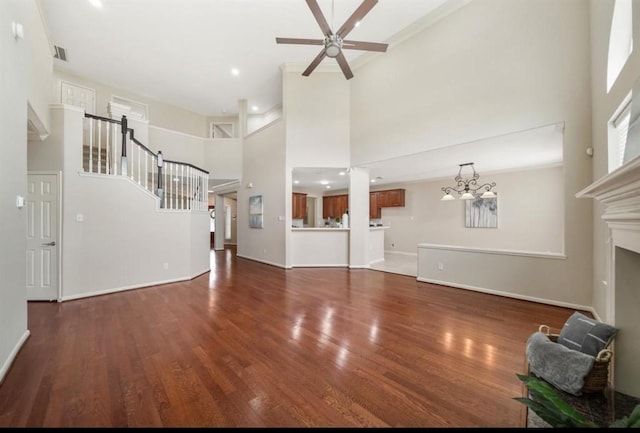 8123 Spring Bluebonnet Dr, Sugar Land, TX 77479 - unfurnished living room featuring a towering ceiling, a ceiling fan, wood finished floors, a chandelier, and a fireplace