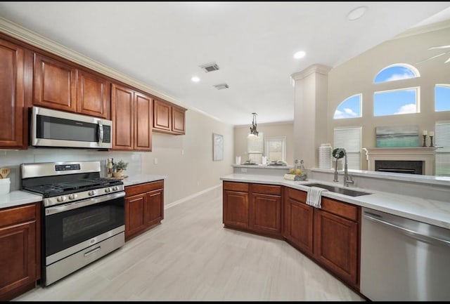 8123 Spring Bluebonnet Dr, Sugar Land, TX 77479 - kitchen with stainless steel appliances, light countertops, recessed lighting, a fireplace, and decorative light fixtures