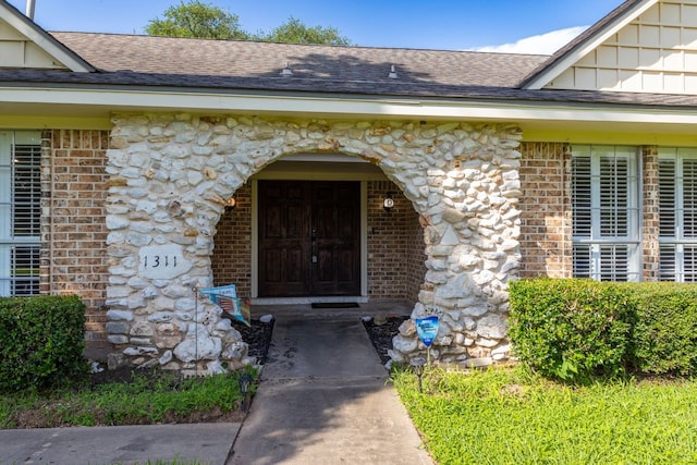 1311 Linwood Dr, Wharton, TX 77488 - entrance to property featuring brick siding, roof with shingles, and stone siding