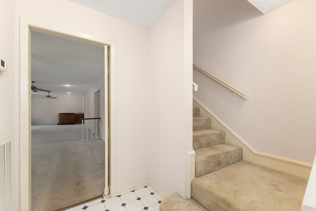 1311 Linwood Dr, Wharton, TX 77488 - staircase with a textured ceiling, ceiling fan, and tile patterned floors