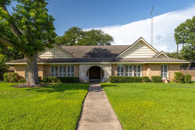 1311 Linwood Dr, Wharton, TX 77488 - view of front of house featuring a front yard, brick siding, and roof with shingles