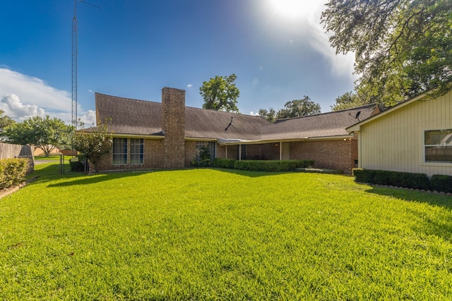 1311 Linwood Dr, Wharton, TX 77488 - back of property featuring a chimney, brick siding, and roof with shingles
