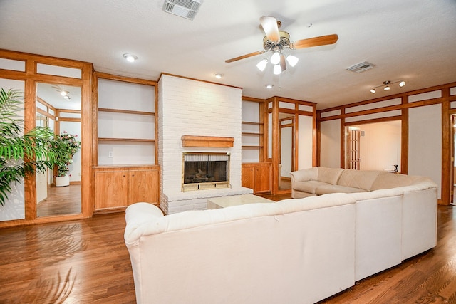 11103 Pembridge Dr, Houston, TX 77071 - living room featuring ceiling fan, wood finished floors, built in features, and a brick fireplace