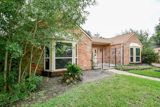 11103 Pembridge Dr, Houston, TX 77071 - view of front of property with brick siding, a gate, and roof with shingles