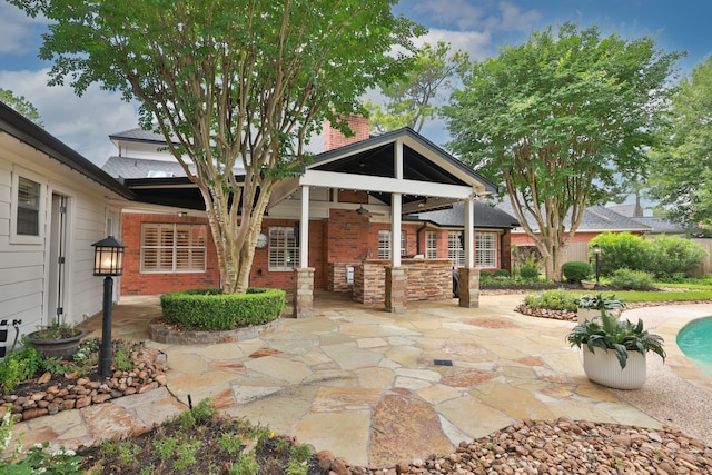 15902 Ivy Bridge Ln, Houston, TX 77095 - back of house with a patio area, a chimney, brick siding, and an outdoor pool