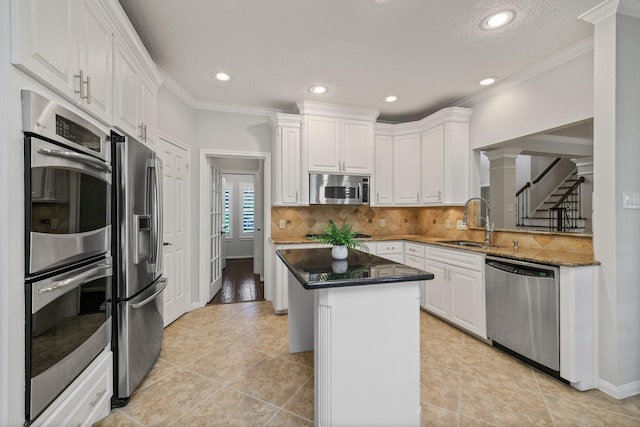 15902 Ivy Bridge Ln, Houston, TX 77095 - kitchen with stainless steel appliances, white cabinets, a kitchen island, backsplash, and recessed lighting