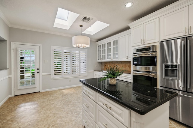 15902 Ivy Bridge Ln, Houston, TX 77095 - kitchen featuring appliances with stainless steel finishes, a skylight, crown molding, white cabinetry, and hanging light fixtures