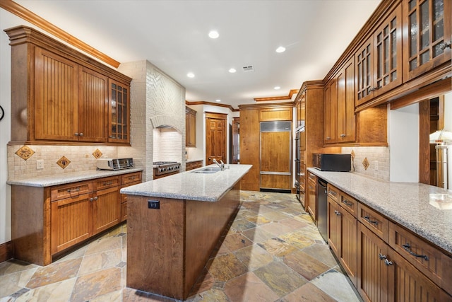 4132 Coleridge St, Houston, TX 77005 - kitchen with stone tile floors, ornamental molding, an island with sink, paneled built in refrigerator, and recessed lighting