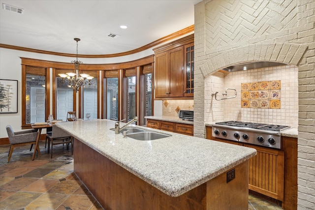 4132 Coleridge St, Houston, TX 77005 - kitchen featuring stone tile flooring, stainless steel gas stovetop, a chandelier, backsplash, and crown molding
