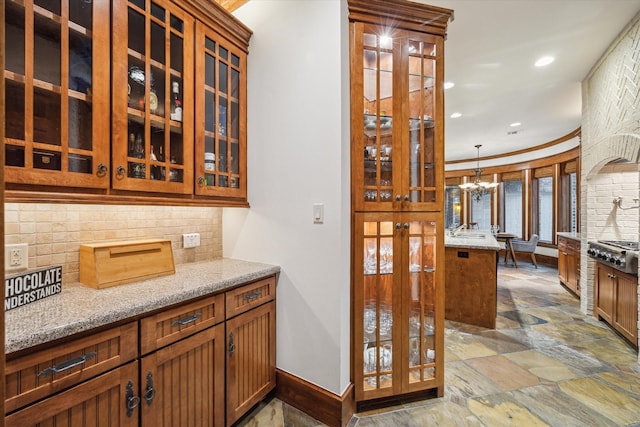 4132 Coleridge St, Houston, TX 77005 - bar area with stone tile floors, tasteful backsplash, a chandelier, recessed lighting, and decorative light fixtures