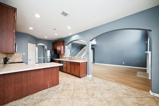 20202 Windsor Trace Ln, Richmond, TX 77407 - kitchen with arched walkways, black appliances, tasteful backsplash, light countertops, and recessed lighting
