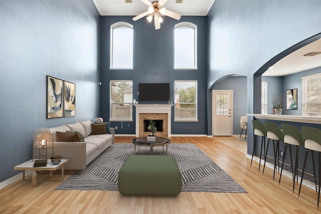20202 Windsor Trace Ln, Richmond, TX 77407 - living room featuring arched walkways, a ceiling fan, wood finished floors, and a high ceiling