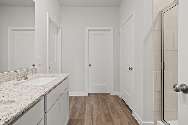 25408 Blossom Ct, Montgomery, TX 77316 - bathroom with wood finished floors, a tile shower, and double vanity