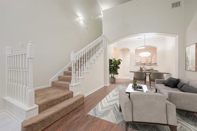 2710 Grants Lake Blvd Unit T6, Sugar Land, TX 77479 - living room with arched walkways, a towering ceiling, stairway, and wood finished floors