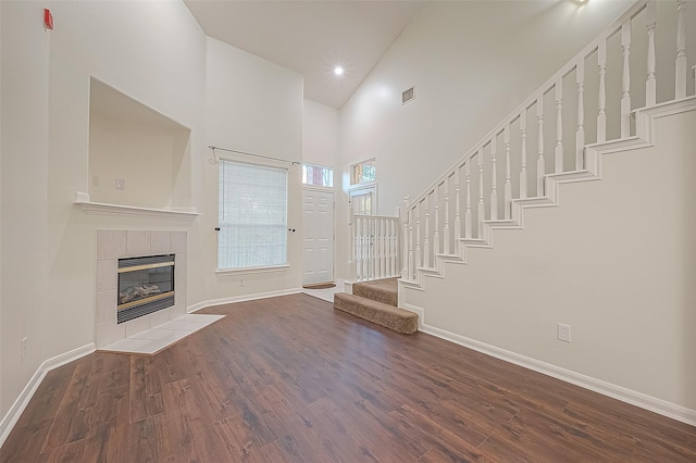 2710 Grants Lake Blvd Unit T6, Sugar Land, TX 77479 - unfurnished living room featuring high vaulted ceiling, wood finished floors, stairway, and a tiled fireplace