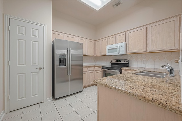 2710 Grants Lake Blvd Unit T6, Sugar Land, TX 77479 - kitchen featuring stainless steel appliances, light tile patterned floors, light brown cabinets, light stone counters, and tasteful backsplash