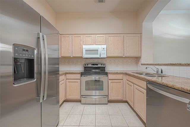 2710 Grants Lake Blvd Unit T6, Sugar Land, TX 77479 - kitchen with stainless steel appliances, light brown cabinetry, decorative backsplash, light tile patterned floors, and light stone countertops