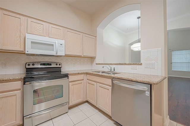 2710 Grants Lake Blvd Unit T6, Sugar Land, TX 77479 - kitchen featuring appliances with stainless steel finishes, ornamental molding, light brown cabinets, decorative backsplash, and arched walkways