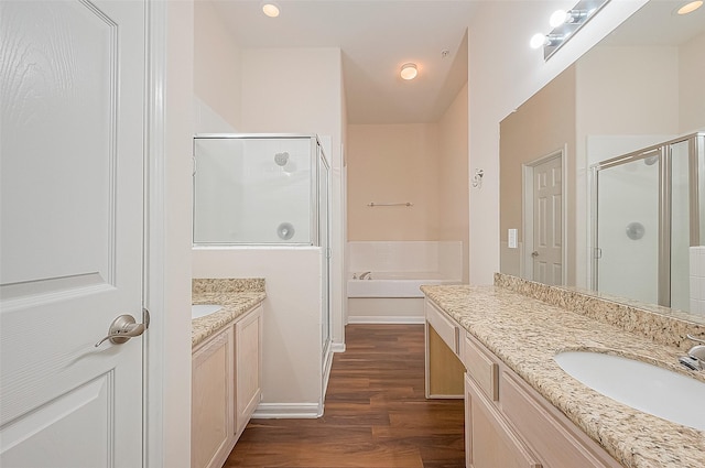 2710 Grants Lake Blvd Unit T6, Sugar Land, TX 77479 - bathroom featuring a stall shower, wood finished floors, two vanities, a bath, and recessed lighting