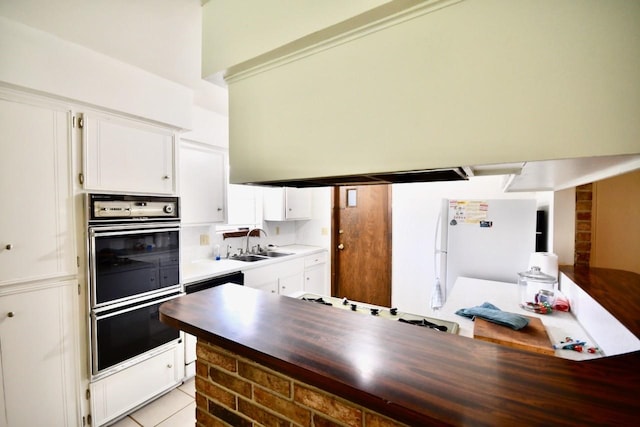 11931 Tanager St, Houston, TX 77072 - kitchen featuring double oven, freestanding refrigerator, white cabinets, cooktop, and light countertops